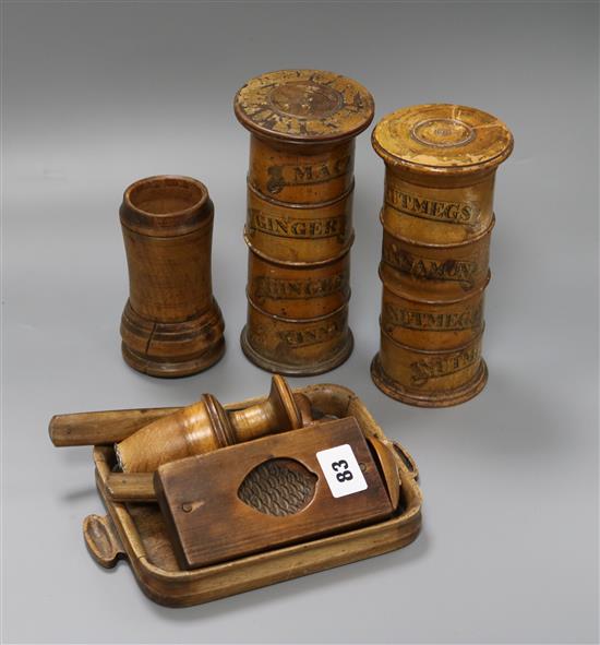 A group of Victorian treen kitchenalia including two spice towers, a pestle grinder and a pine cone butter mould